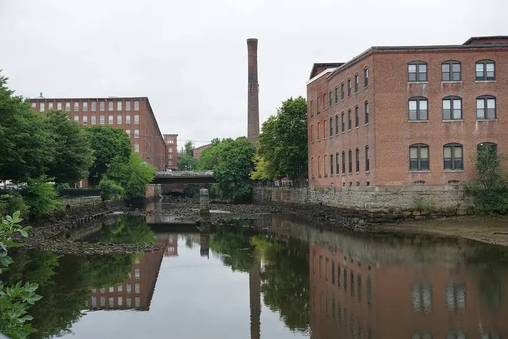 Brick mill buildings reflected in the Cocheco River at Henry Law Park in Dover, New Hampshire