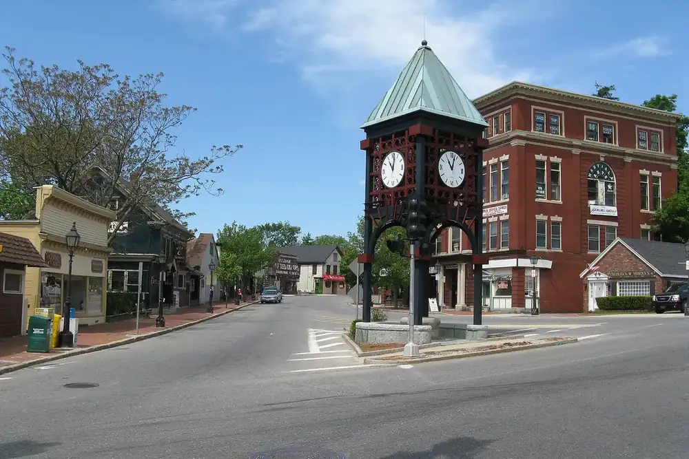 Clock tower at Gaunt Square with brick buildings along the street in Methuen, Massachusetts