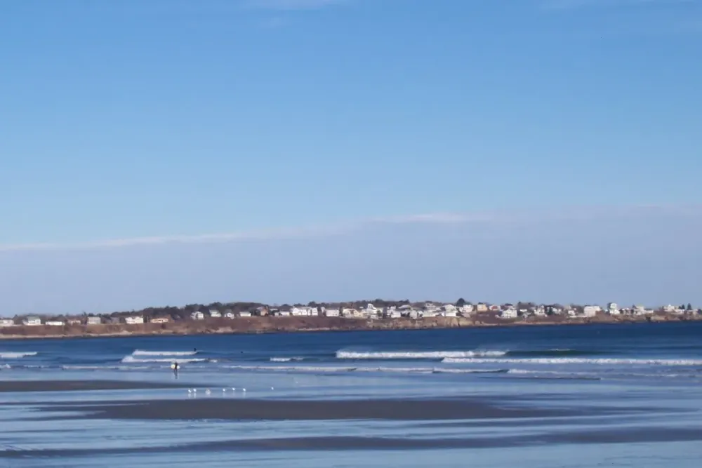 Cape Neddick seen across the ocean from Long Sands Beach in York, Maine